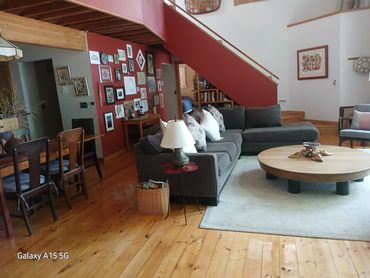 Cozy living room with gray sectional sofa and wooden dining area.