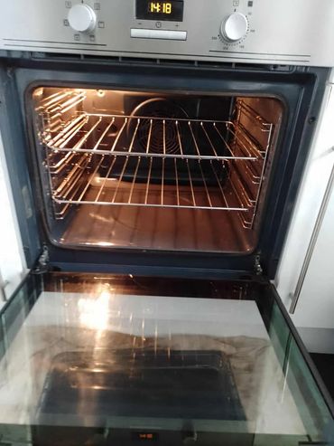 Open, clean oven with two racks and digital controls.