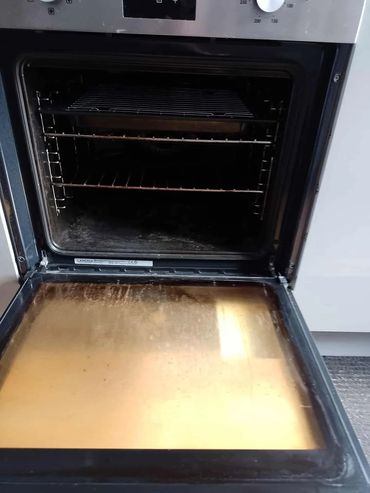 Open kitchen oven with racks and a clean door interior.