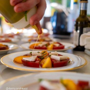 Garnishing fresh Mozzarella and Heirloom Tomato Salad