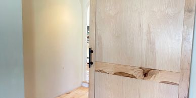 Light wooden sliding barn door on a hardwood floor.