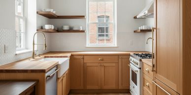 Cozy kitchen with wooden cabinets, open shelves, and a farmhouse sink under a window.