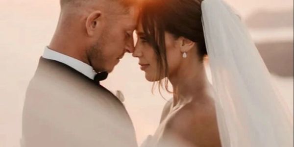 A bride and groom share a tender moment forehead to forehead on their wedding day.