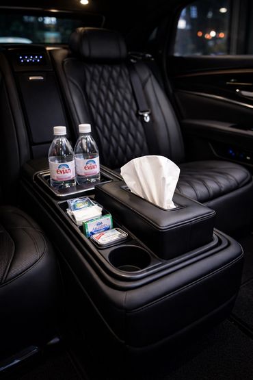 Luxurious car interior with black leather seats and amenities.