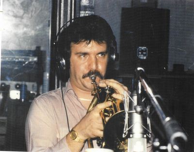 Master music instructor Greg Koss playing the trumpet at a recording studio