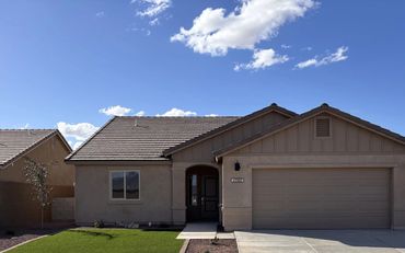 Modern single-story house with beige exterior and clear blue sky.