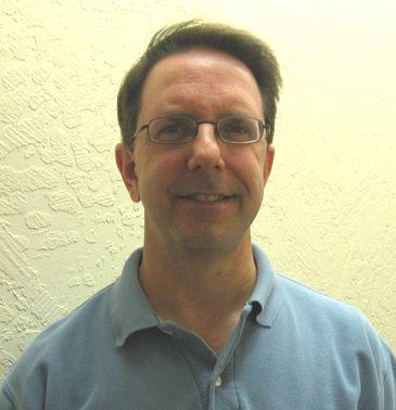 Man wearing glasses and a blue polo shirt.