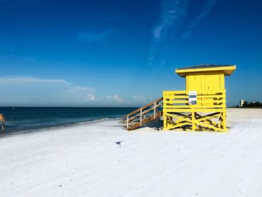 Yellow lifeguard stand on Siesta Beach on a clear day.