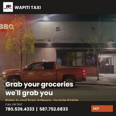 Wapiti Taxi truck parked at night, offering grocery rides.