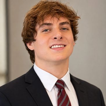 Young man in suit and tie smiling.