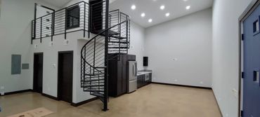 Modern interior with spiral staircase and compact kitchen area.
