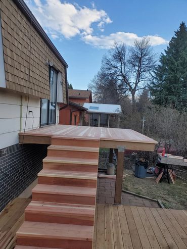 New wooden deck and stairs under construction outside a house.
