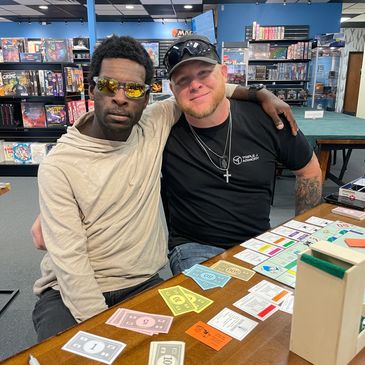 Two friends enjoying a board game session together in a game store.
