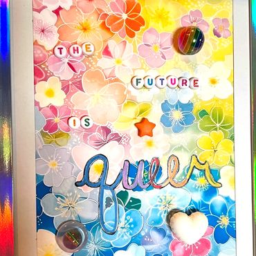 Colorful floral artwork with the phrase 'The future is queer' spelled out with beads and decorations.