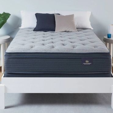 Modern bed with a gray mattress and white frame, flanked by two white nightstands.