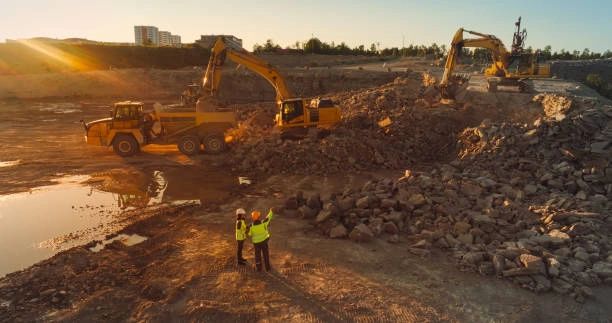 Active civil development site with excavation equipment and field personnel