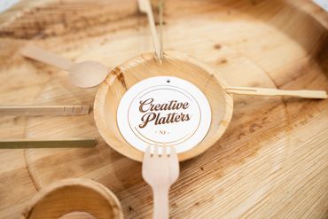 Wooden utensils arranged around a bowl labeled Creative Platters.