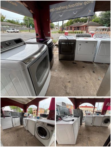 Used washers and dryers displayed outside a store.