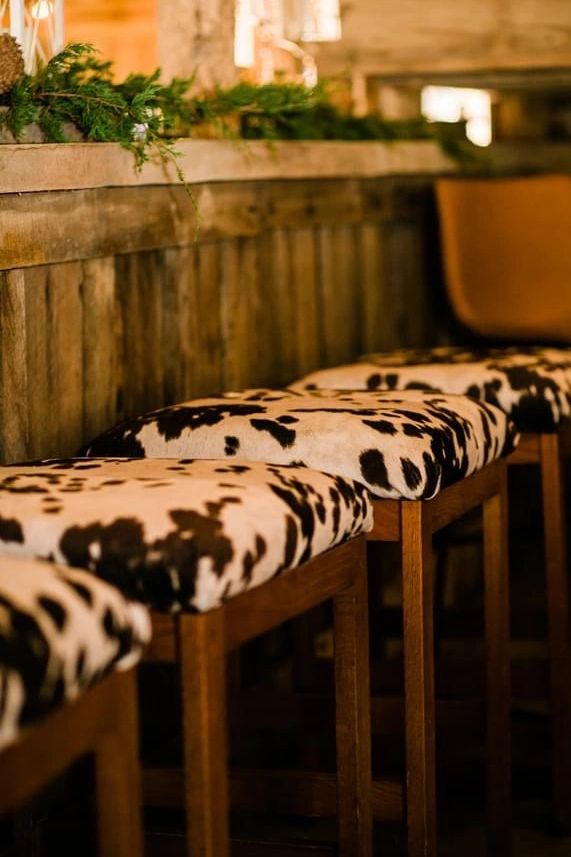 Cowhide bar stools and chairs with farm tables