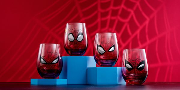 Four Spider-Man themed glasses on blue blocks with a red spider web background.