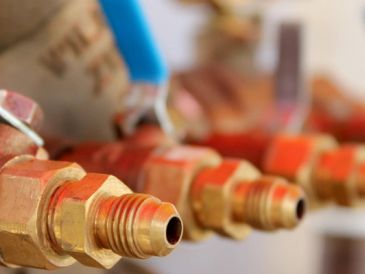 Close-up of brass plumbing fittings with orange seals.
