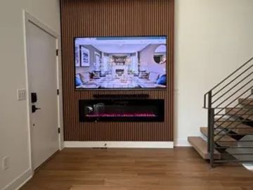 Modern living room wall with TV and electric fireplace.