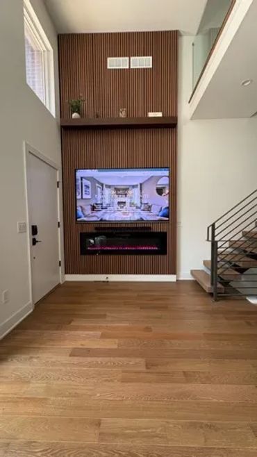 Modern accent living room wall with TV hidden wires and electric fireplace.