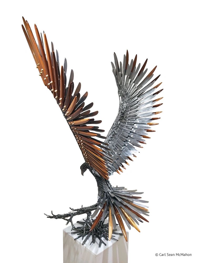 Rear-left view of hawk sculpture showing wing spread and fine cedar featherwork over metal frame.