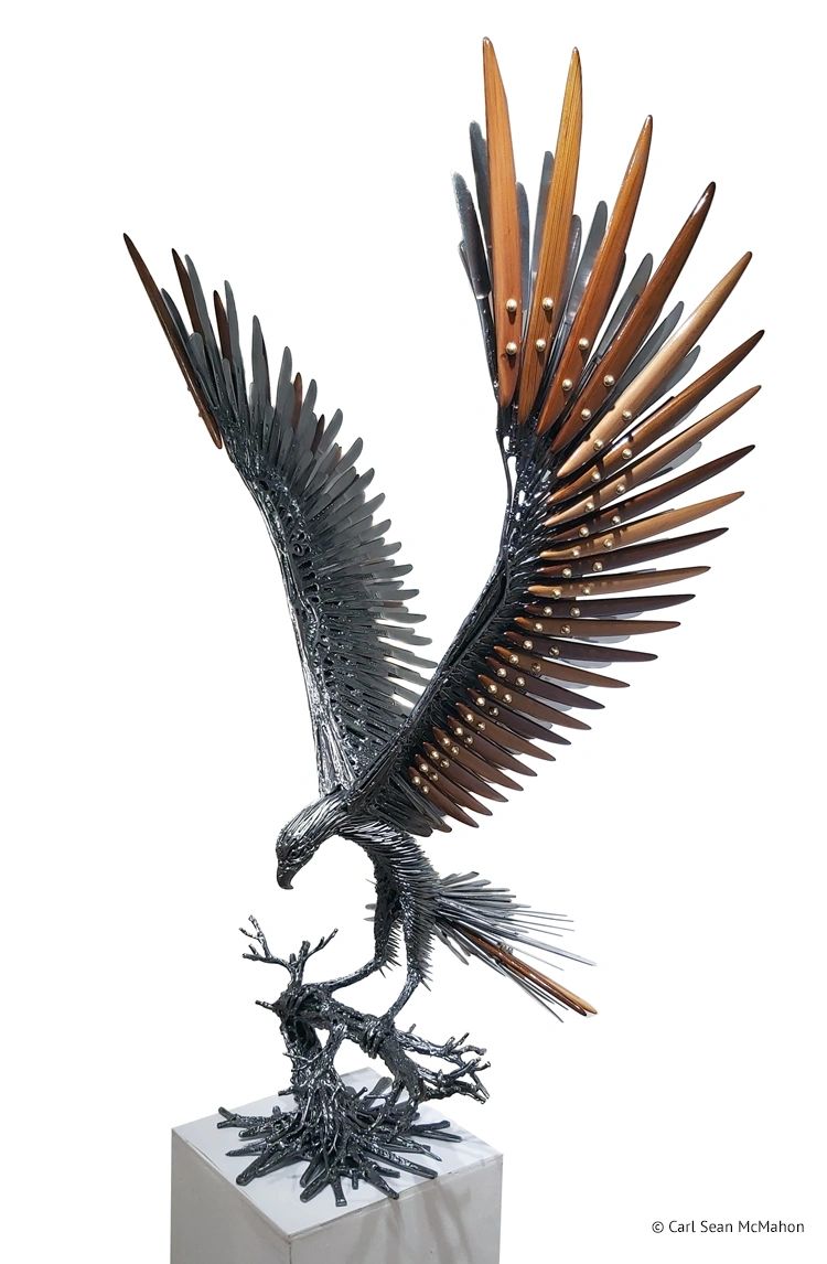 Front-left angle of small hawk sculpture featuring metal structure and layered cedar feather detail.