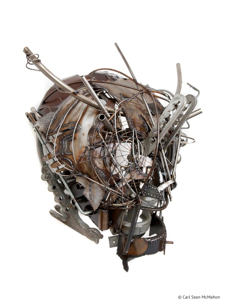 Angled view of 20th Century Man mask with layered patinaed steel in fractured, open component layout