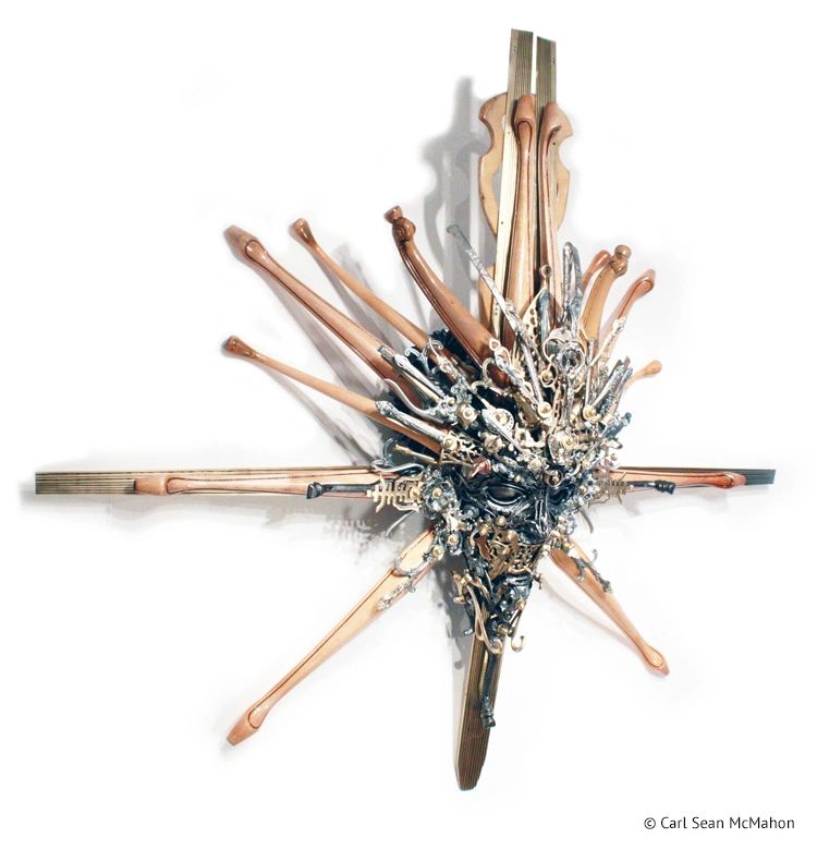 Nexus IV mask sculpture with sculpted detail in brass and steel, seen from front right angle