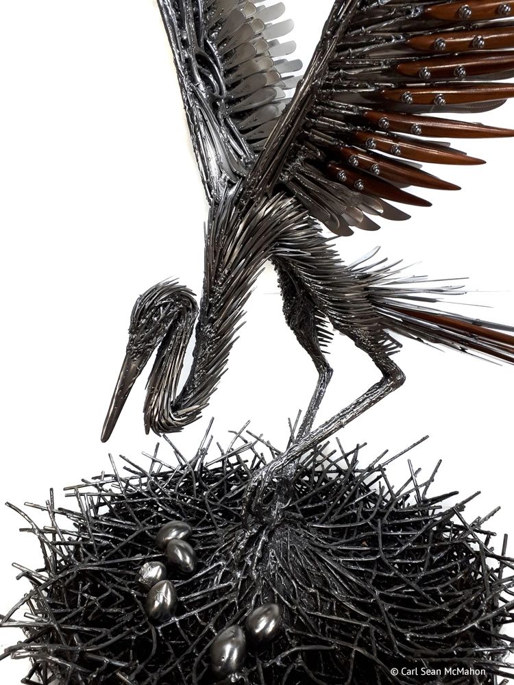 Close-up of heron head, chest, and nest showing eggs and layered red cedar highlights over metal bas