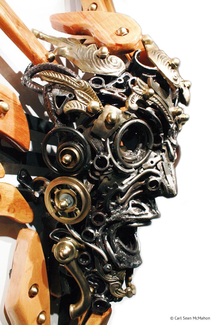 Side profile of Nexus II mask sculpture with layered steel and brass, clad in reclaimed pine wood