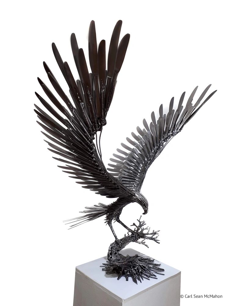 The Goshawk sculpture in recycled metal with upright stance and detailed wingwork on tree base