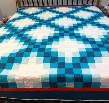 Custom made quilt in a triple Irish Chain pattern in shades of turquoise and teal.