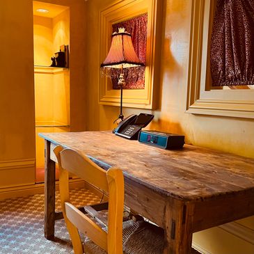 A wood desk, wood table, lamp and built in bookcase. Picture by Cate Lumière.