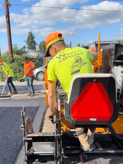 Western Washington Asphalt worker laying down asphalt with asphalt paving equipment.