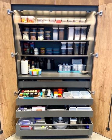 Neatly organized kitchen pantry with clear containers and various cooking supplies.