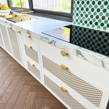A beautiful modern kitchen countertop featuring charming gold accents and a stylish tiled backsplash.