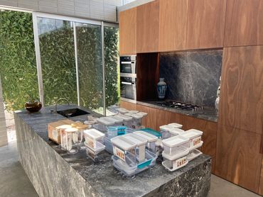 Contemporary kitchen featuring wooden cabinetry and granite work surfaces. Added containers for the pantry