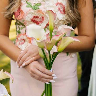 Woman holding a bouquet of calla lilies.