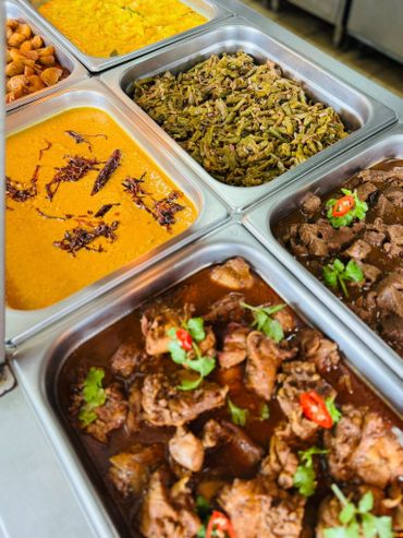 A variety of cooked dishes in metal containers ready to serve.
