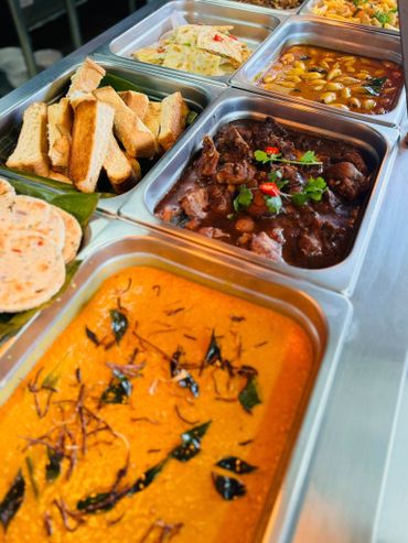 A colorful buffet spread featuring bread, curries, and flatbreads.