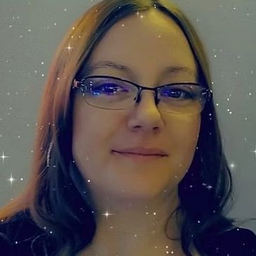 Woman with glasses smiling against a starry, sparkly background.