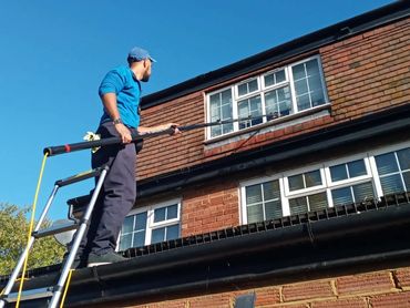 Professional gutter cleaning on two-storey house in Ealing to prevent overflow damage.