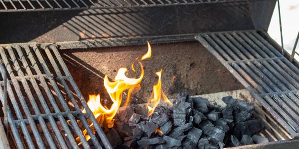 Charcoal grill with burning flames and black coals.