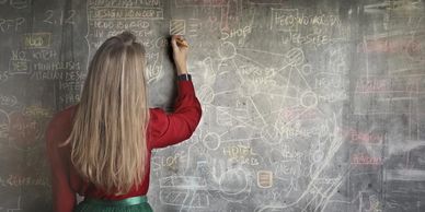 Woman writing on digital chalkboard symbolising data in modern education