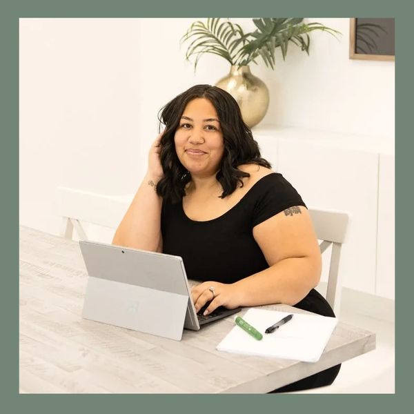 Woman working on a laptop in a bright, modern office with minimalistic decor.