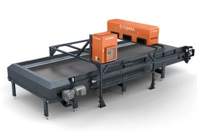 Industrial sorting machine with conveyor belts and TOMRA branding.