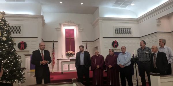 A group gathered in a church during a ceremony.